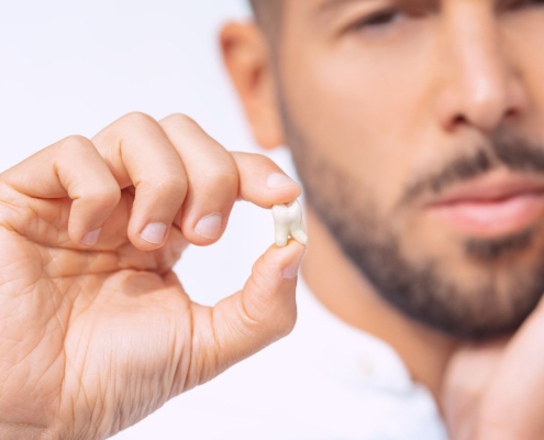 Man holding broken tooth.