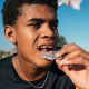 Athlete putting on dental protection for athletes.